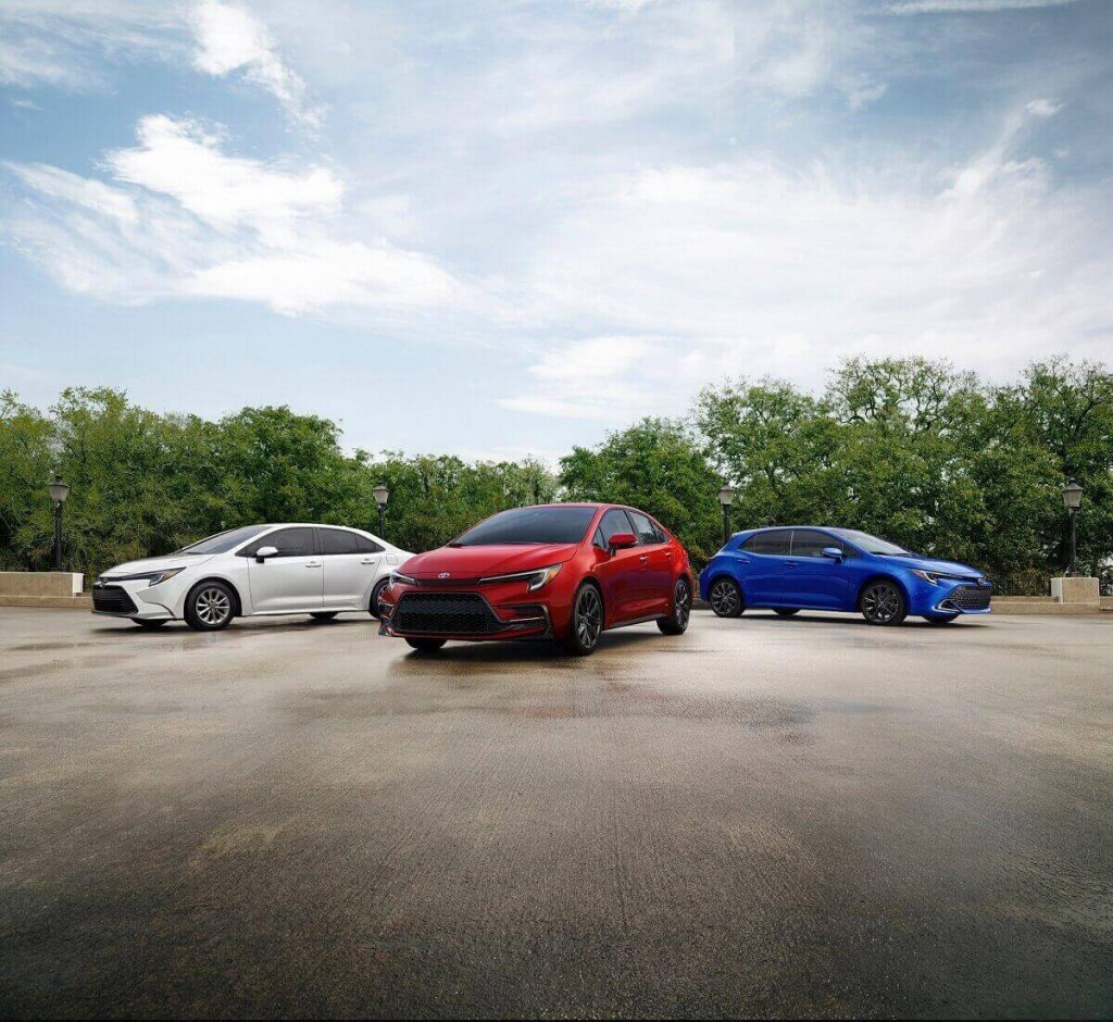 A trio of 2023 Toyota Corolla AWD Hybrids and Hatchbacks poses in a park. 
