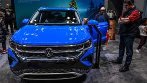 A blue 2023 Volkswagen Taos parked indoors.