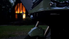 2023 Zero DSR/X parked in front of a cabin a dusk.