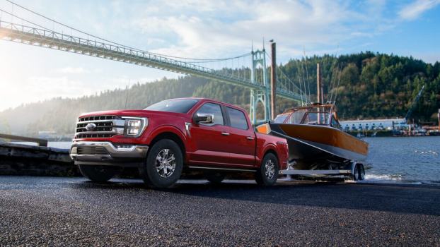 A 2023 Ford F-150 full-size truck tows a boat out of water.