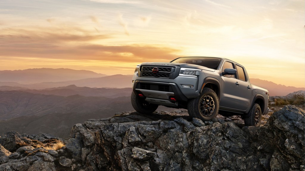 A 2023 Nissan Frontier midsize truck is parked on rocky terrain.