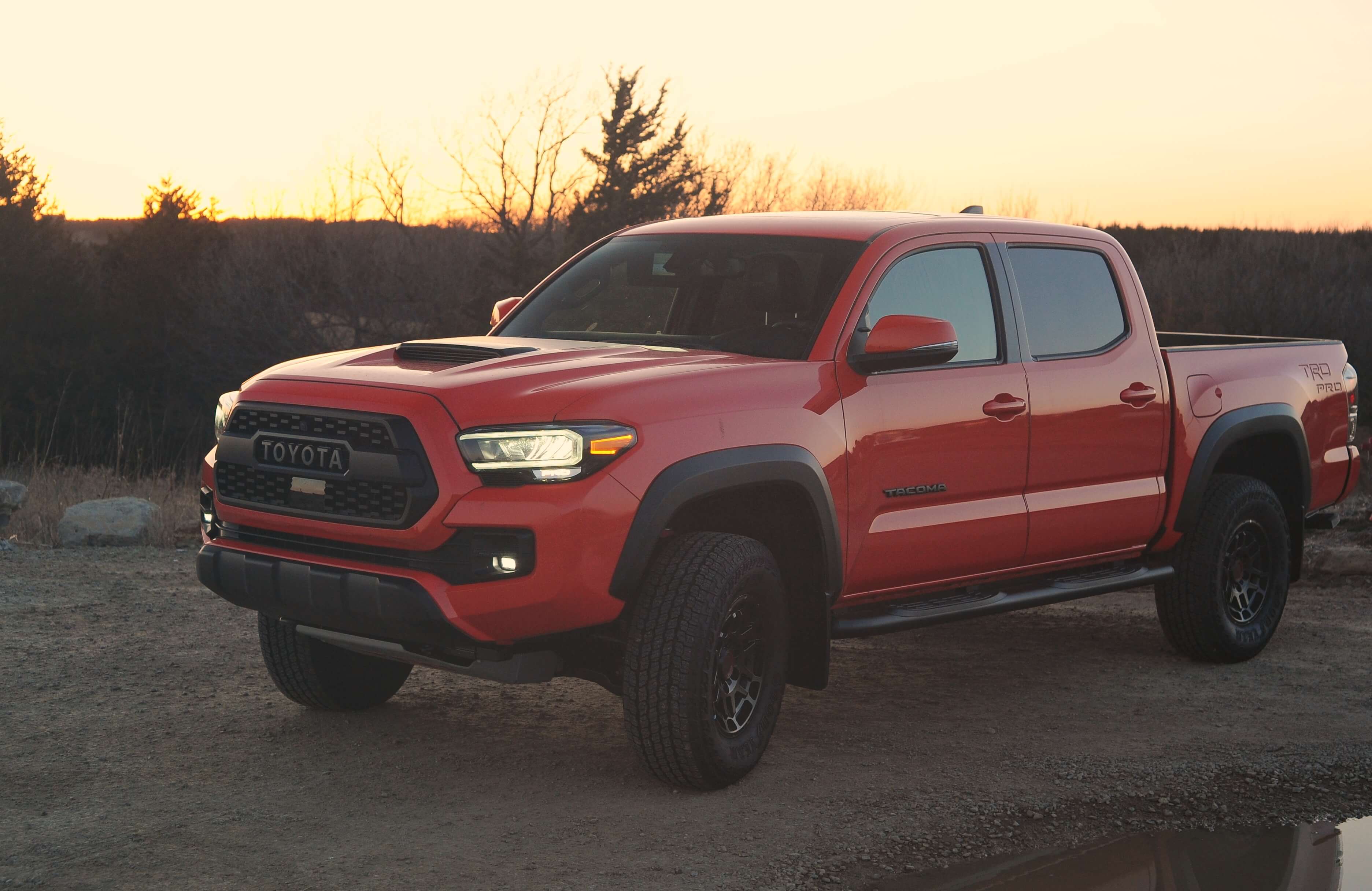 A red Toyota truck is doing some light off-roading.