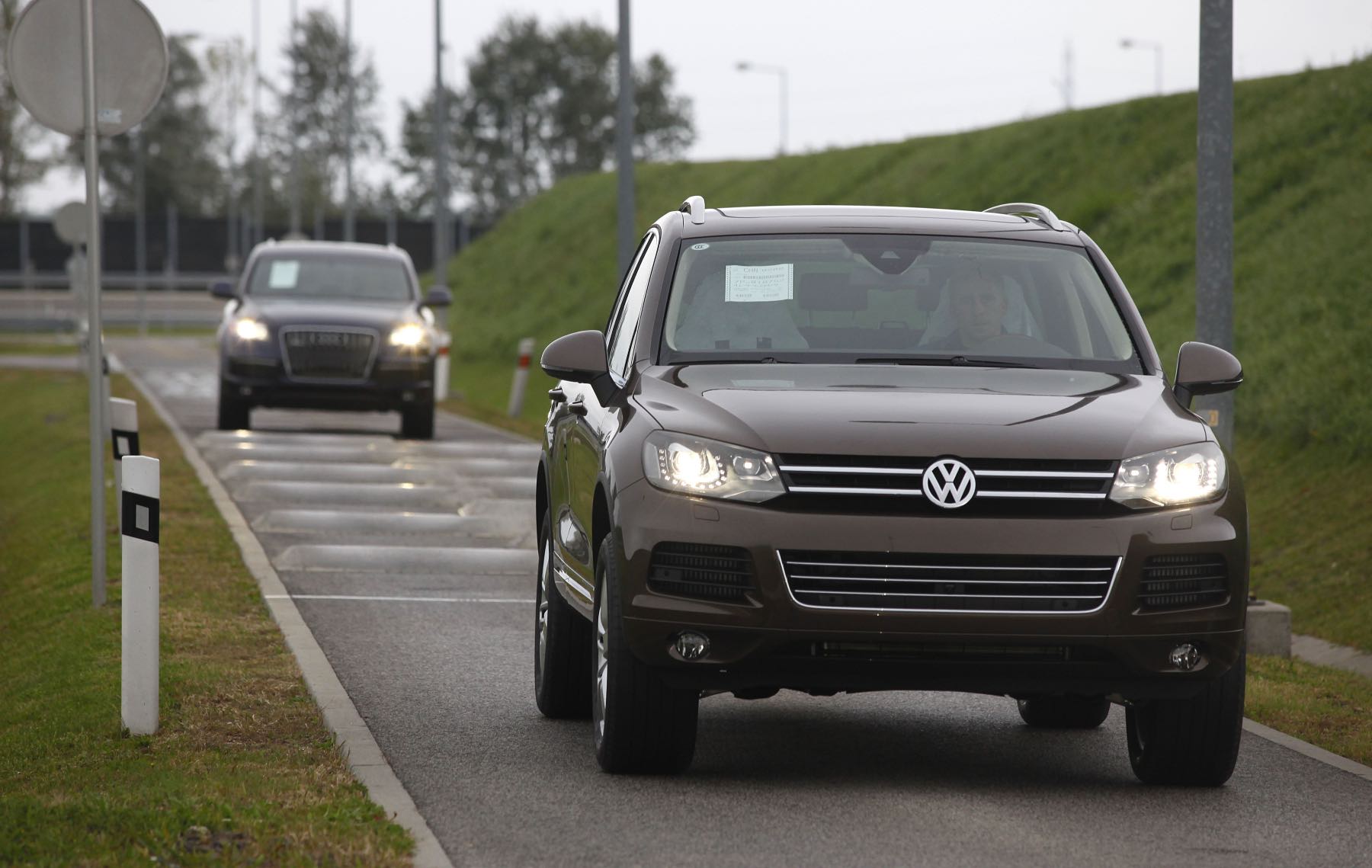 A Volkswagen Touareg undergoes testing. An Audi follows behind in the background.