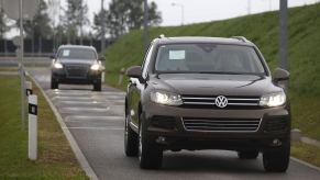 A Volkswagen Touareg undergoes testing. An Audi follows behind in the background.