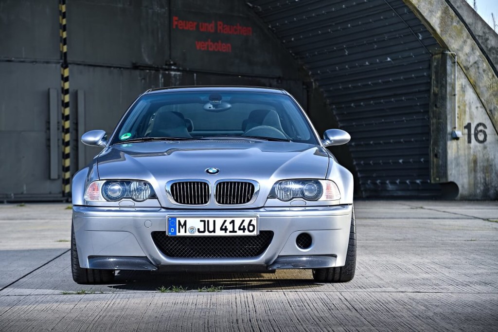 A used 2003 BMW 3 Series car, like the 325i, poses next to a German sign. 