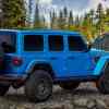 Rear view of a Jeep Wrangler Rubicon, ranked among the best SUVs for tall people, in an alpine forest.