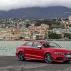 A bright-red 2015 Audi S3 shows off its sports car styling by the coast.