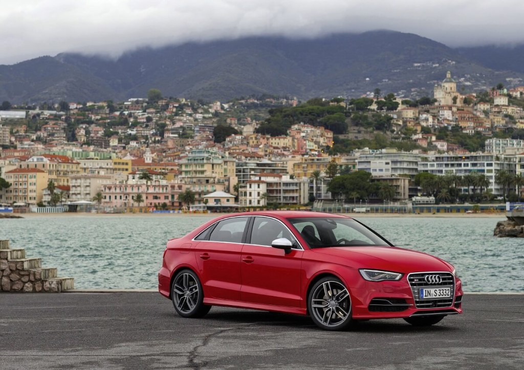 A bright-red 2015 Audi S3 shows off its sports car styling by the coast. 