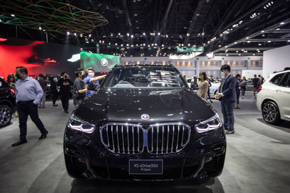 A black BMW X5 on display at an auto show.