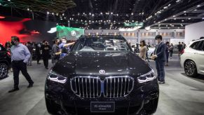 A black BMW X5 on display at an auto show.