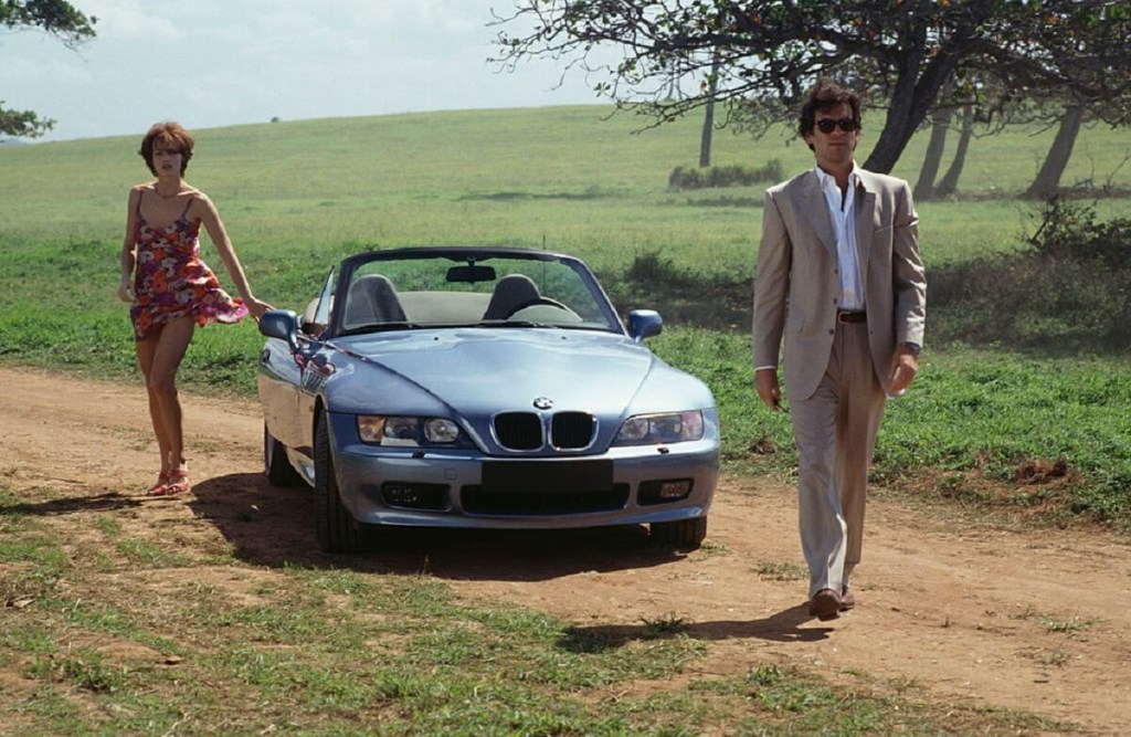 Pierce Brosnan walks away from a BMW Z3 sports car in a James Bond film. 