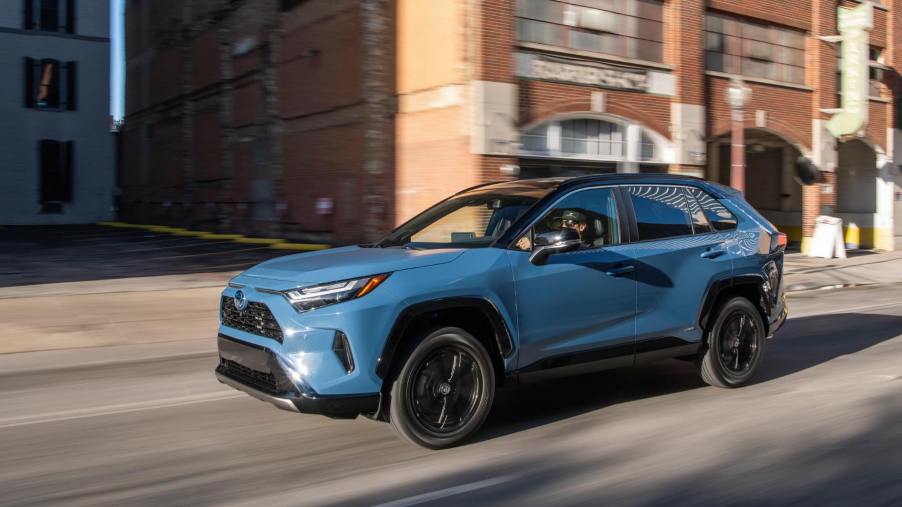 A blue Toyota RAV4 drives on a city street. The RAV4 failed to earn the title of best compact SUV for the money.