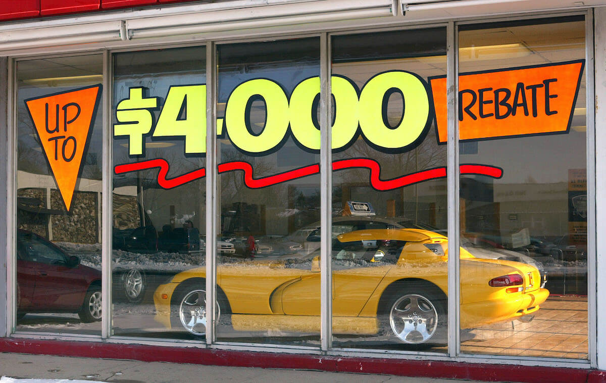 A yellow Dodge Viper sits in a dealer showroom.