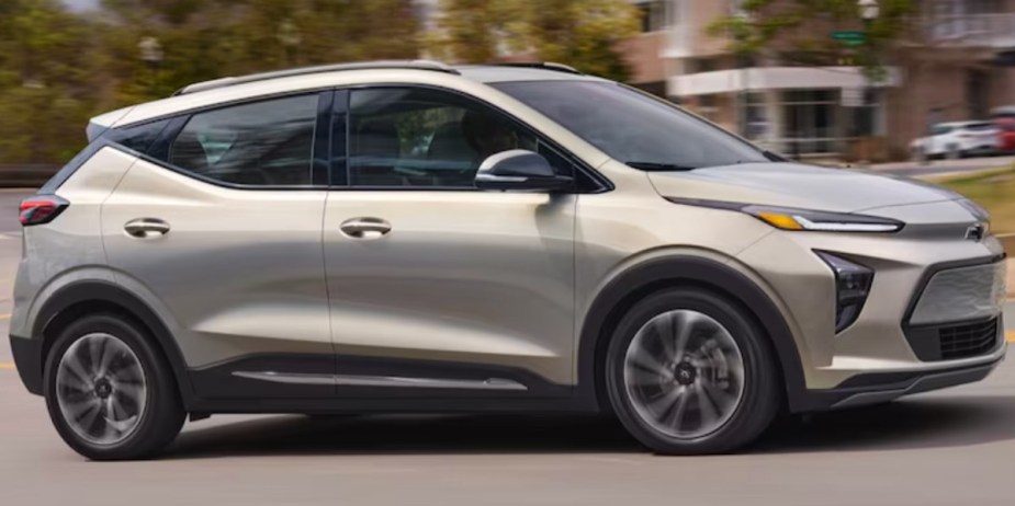A gray Chevy Bolt EUV subcompact electric SUV is driving on the road. 