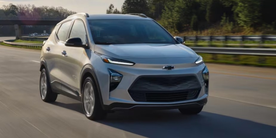 A gray 2023 Chevrolet Bolt EUV subcompact electric SUV is driving on the road. 