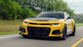 Yellow Chevy Camaro ZL1 driving on a road. This is a seriously aggressive and awesome muscle car.