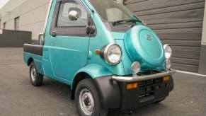 This is a 1996 Daihatsu Midget II compact pickup truck, with a front-mounted spare tire.