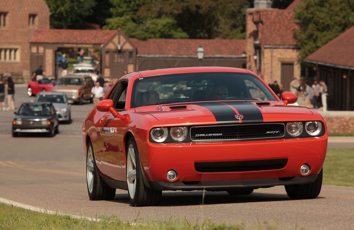 A Dodge Challenger SRT8 cruises ahead of other Mopar cars like Hellcats and Vipers.