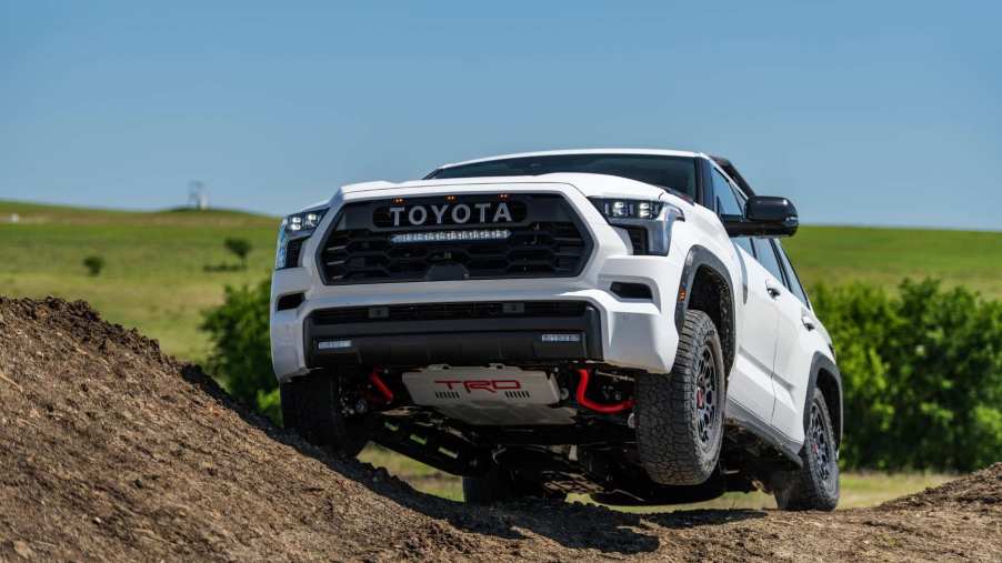 A white 2023 Toyota Sequoia TRD Pro demonstrates its capabilities on an off-road trail. The Sequoia is one of Toyota's reliable large SUVs