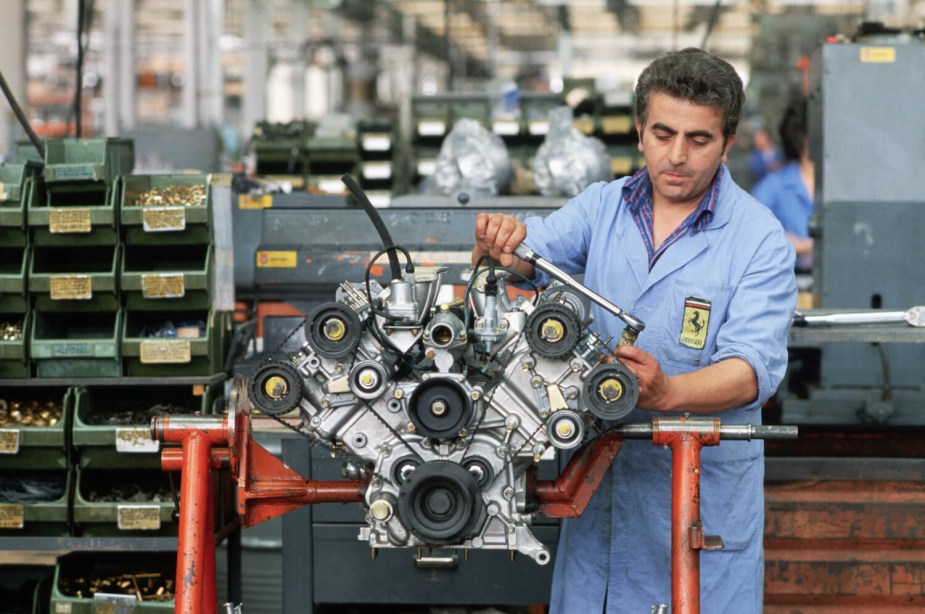 A Ferrari factory worker hand assembles a V12 engine at the plant in Maranello, Italy.