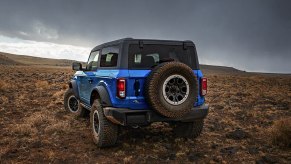 A blue 2023 Ford Bronco midsize SUV is parked off-road.