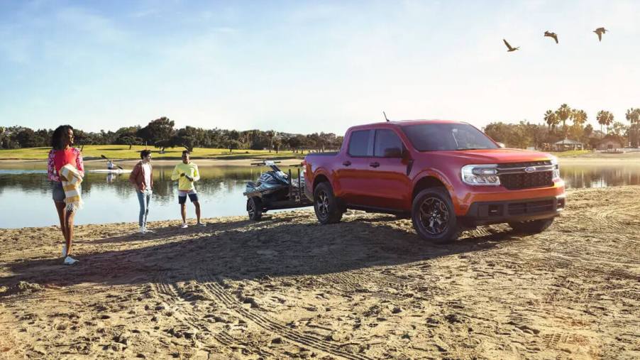 A 2023 Ford Maverick tows a boat out of the water as a small truck.