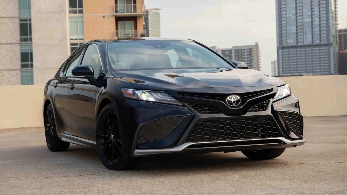 Front angle view of black 2023 Toyota Camry, showing that its name means the same as Corolla and Crown