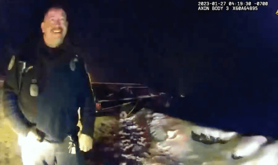 A hearse dangling off of a cliff