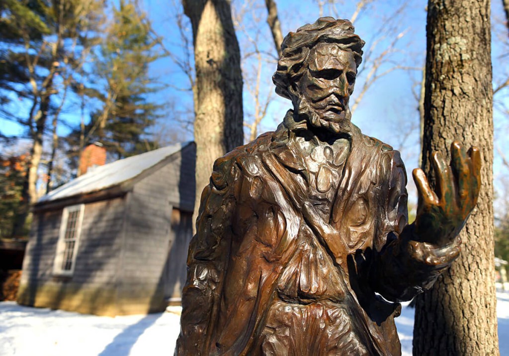 A statue of Henry David Thoreau outside of his cabin at Walden Pond.