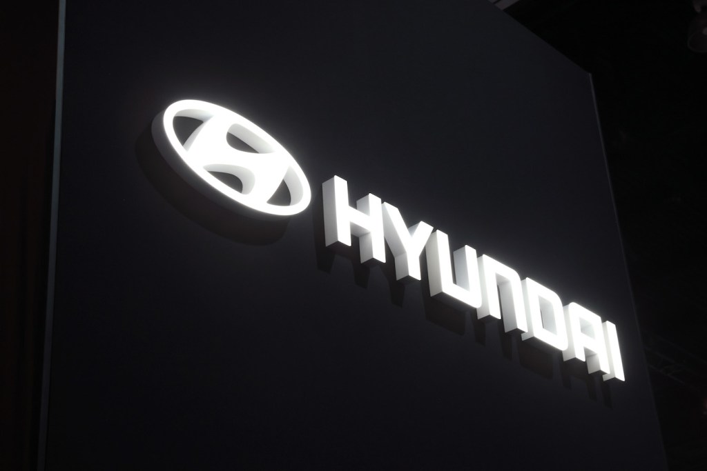 The Hyundai logo lit up at night. The Hyundai Scoupe from the 90s is the Hyundai with the lowest annual maintenance costs.