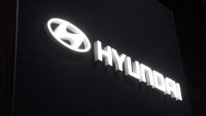 The Hyundai logo lit up at night. The Hyundai Scoupe from the 90s is the Hyundai with the lowest annual maintenance costs.