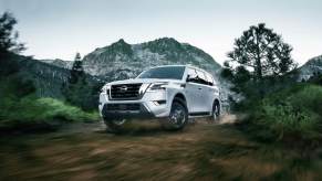The 2023 Nissan Armada shows off its reliability while driving off-road in front of a mountain.