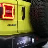 The back of a yellow Jeep Wrangler 4xe at an auto show.