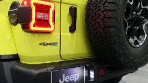 The back of a yellow Jeep Wrangler 4xe at an auto show.