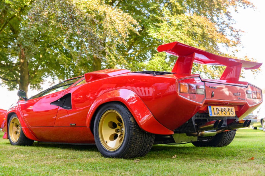 A red Lamborghini Countach is parked.