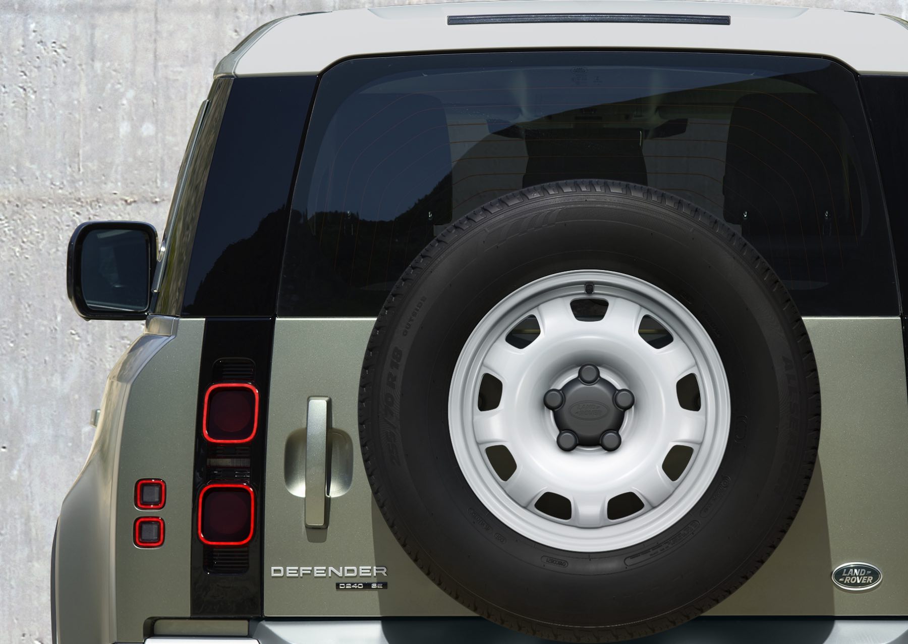 The rear-mounted spare steel wheel on a Land Rover Defender.