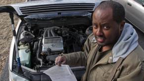 Yonas Bekele showing off fire damage to his 1993 Lexus car that happened during a routine oil change
