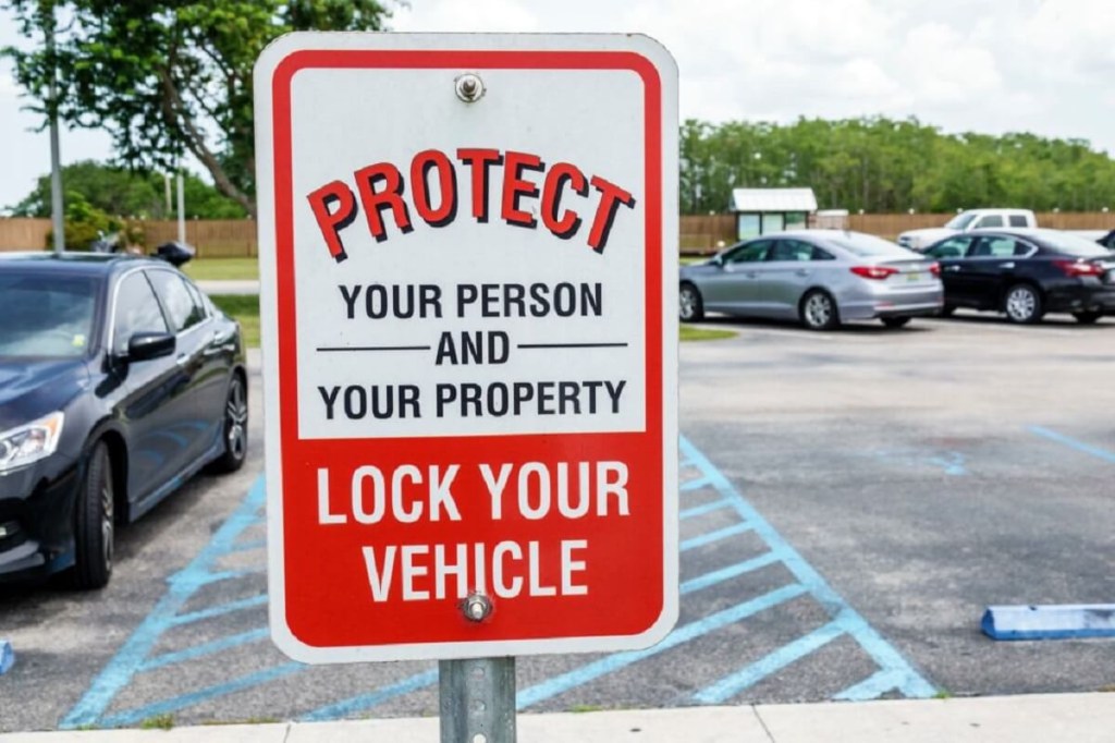 A sign reminds patrons to lock their vehicles to defend against stolen cars and property that could lead to branded or salvage titles. 