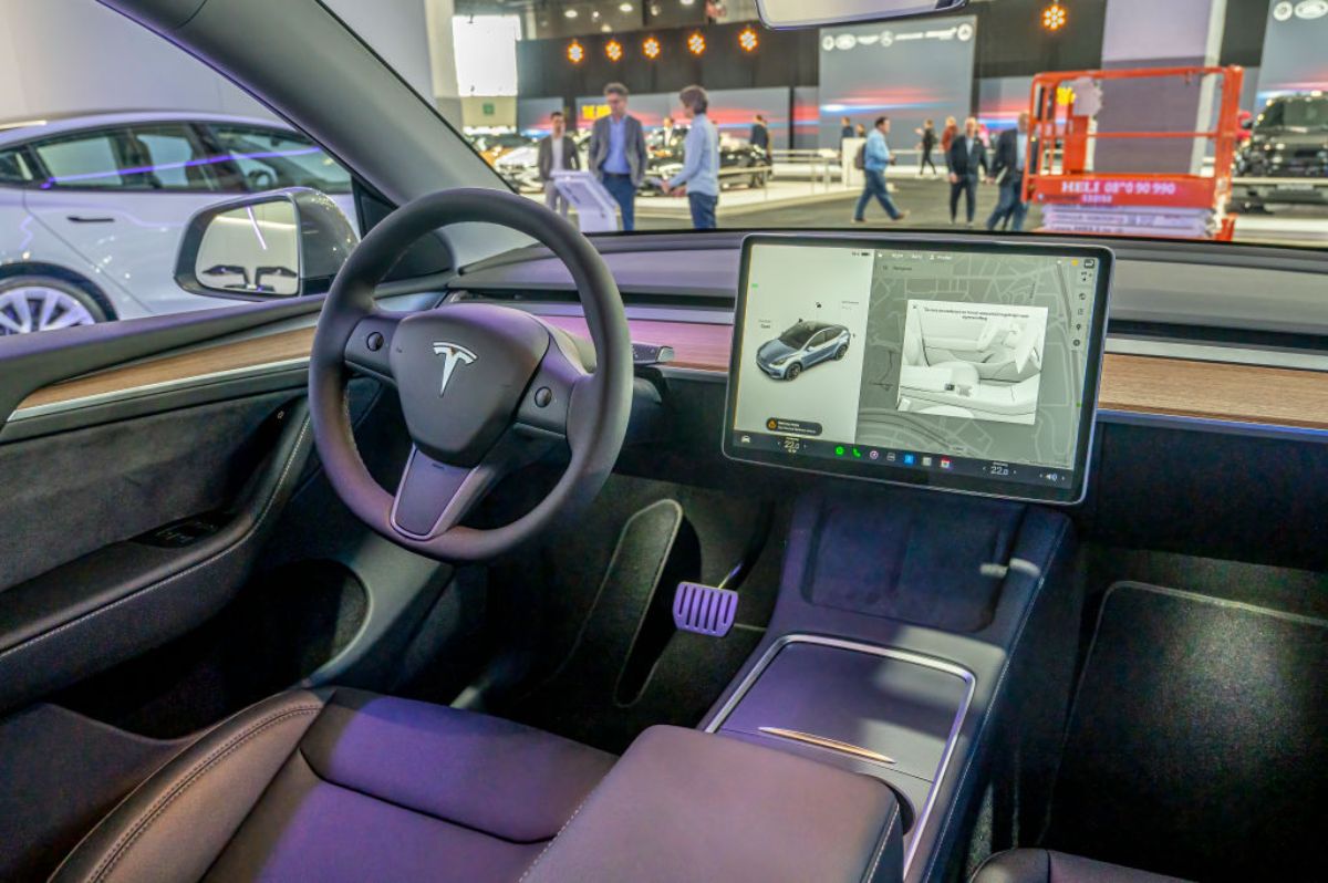 An interior view of a Tesla looking out from the passenger seat.