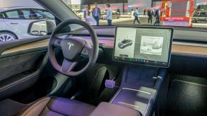 An interior view of a Tesla looking out from the passenger seat.