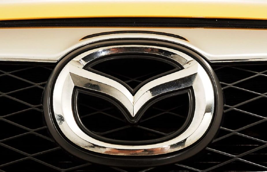 A Mazda3 car badge shines on a yellow front end.