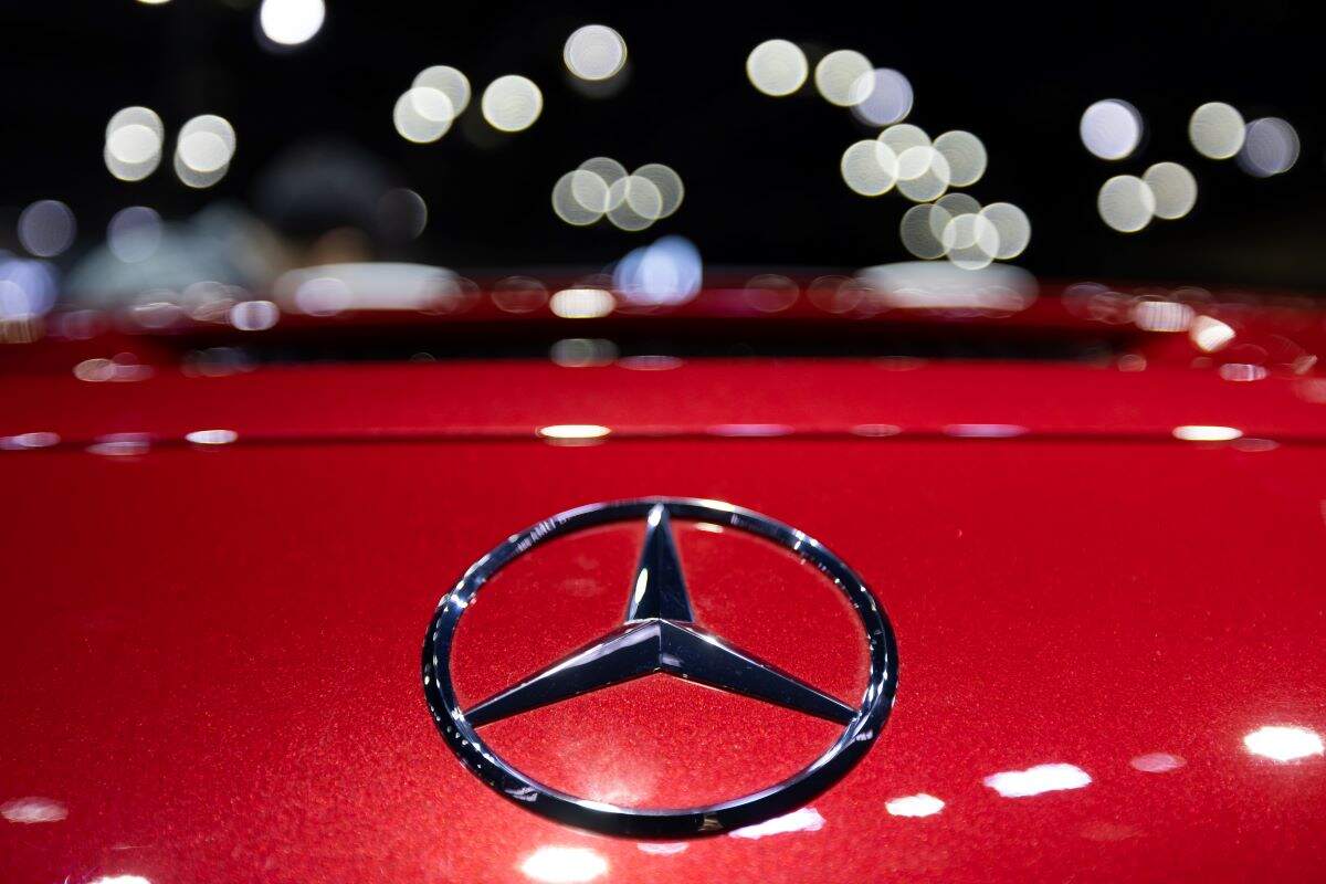 A Mercedes-Benz logo on the front of a red Mercedes-Benz vehicle.