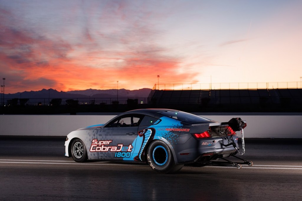 An electric Ford Mustang Super Cobra Jet 1800 shows off its rear-end on a drag strip.