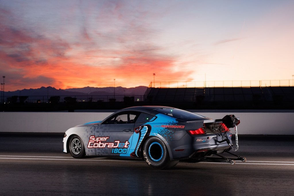 An electric Ford Mustang Super Cobra Jet 1800 shows off its rear-end on a drag strip. 