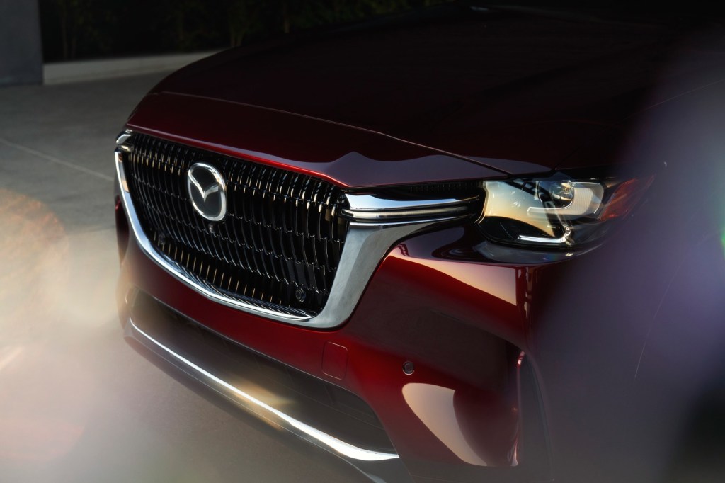 Angled view of the new Mazda CX-90 SUV front fascia in red.