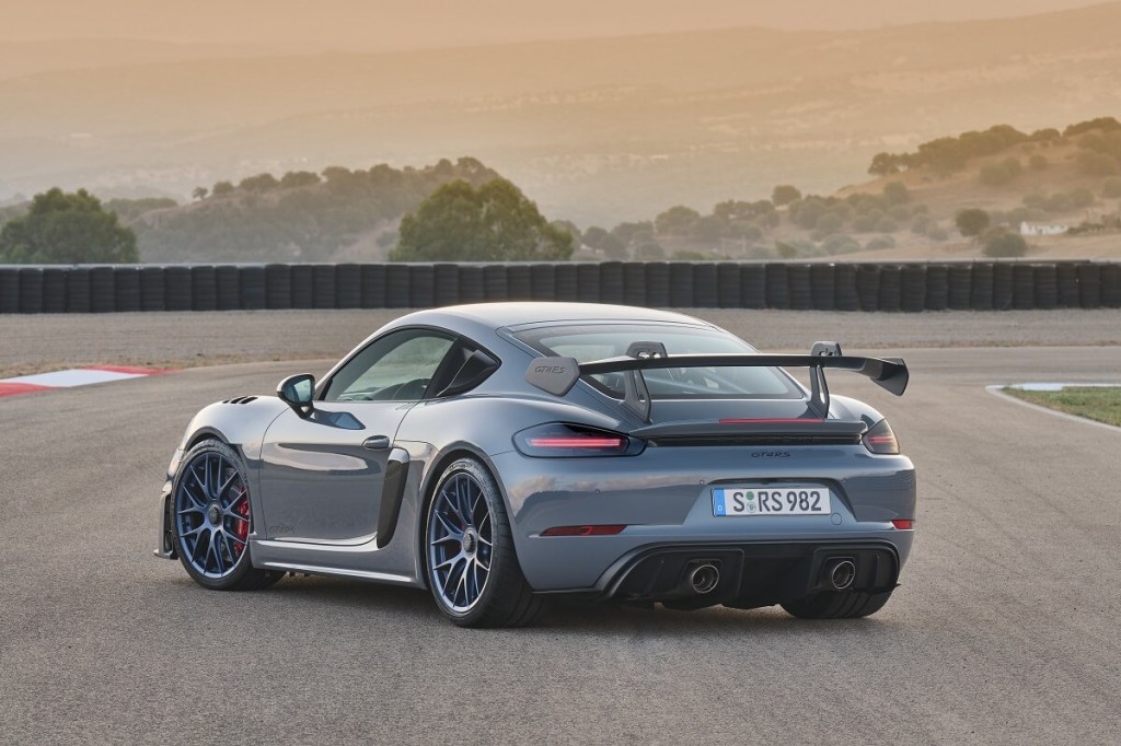 A gray Porsche 718 Cayman GT4 RS poses on a track. 