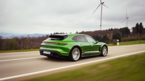A 2023 Porsche Taycan Cross Turismo station wagon blasts across an open road.