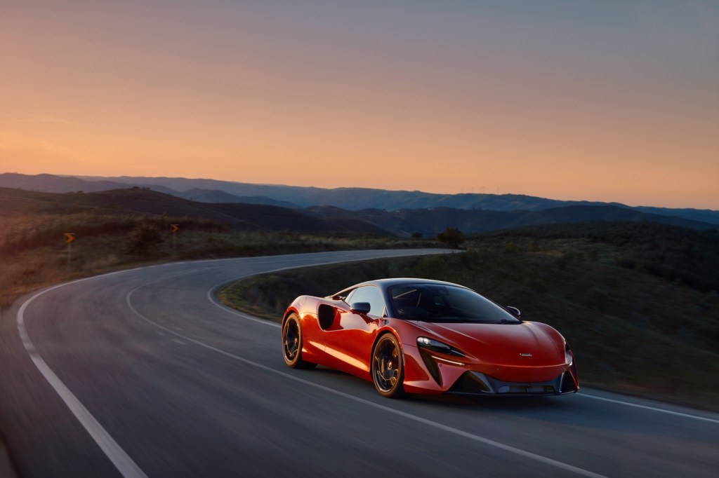 A red McLaren Artura on a winding mountain road 