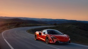 A red McLaren Artura on a winding mountain road