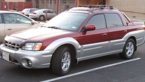 A red Subaru Baja pickup truck sits in a parking lot.